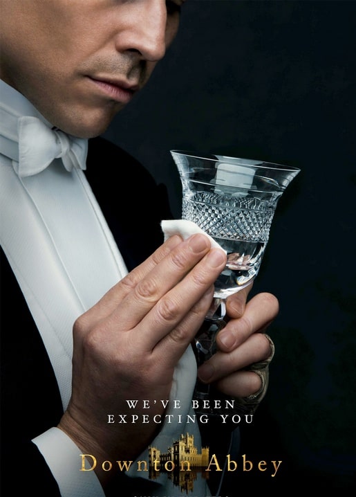 Postkarte zum Downton-Abbey-Film, ein Butler poliert ein Kristallweinglas im gedämpften Licht