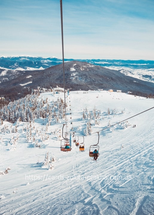 Chairlift carrying skiers above snowy pines at Dragobrat ski resort
