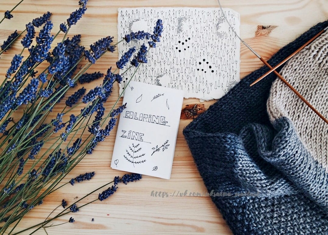 Getrockneter Lavendel, ein handgezeichnetes Zine und Stricknadeln auf Holztisch