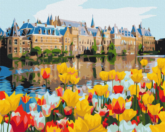 Dutch palace with towers reflected in a canal, surrounded by red and yellow tulips