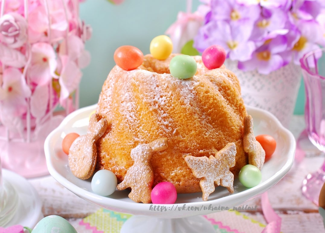 Powdered-sugar Easter bundt cake with candy eggs and bunny-shaped cookies