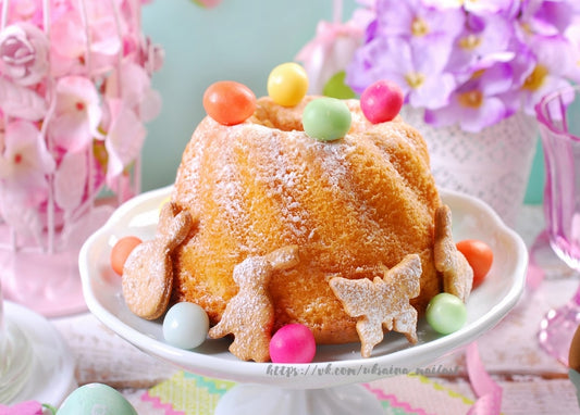 Powdered-sugar Easter bundt cake with candy eggs and bunny-shaped cookies