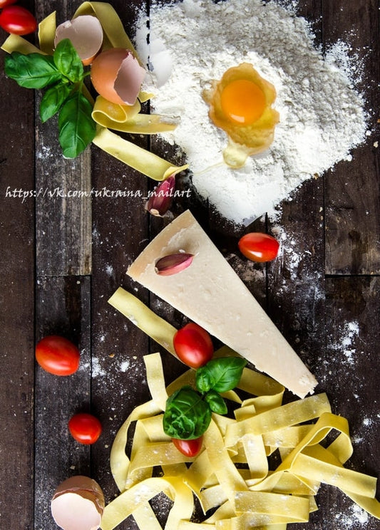 Aufgeschlagenes Ei in Mehl mit Basilikum, Parmesan, Tomaten und Tagliatelle