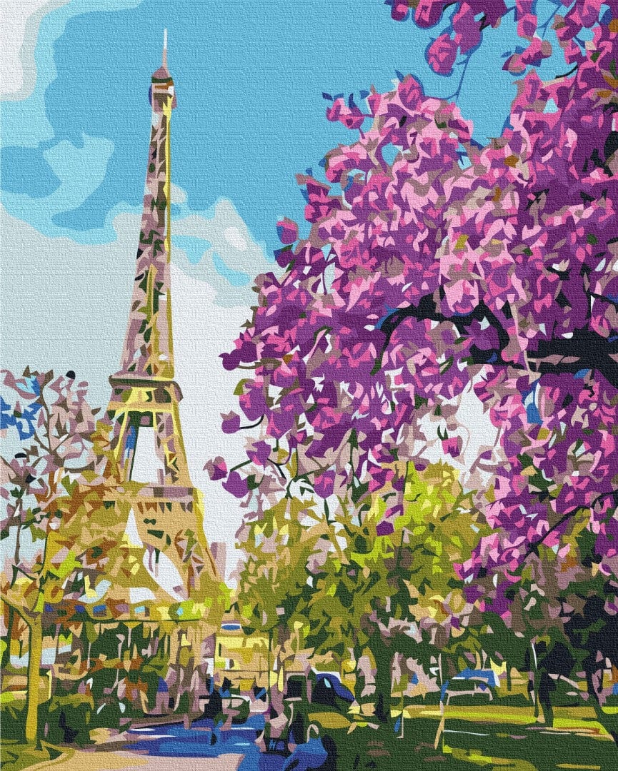 Eiffel Tower framed by branches of pink and purple blossoms in a Paris park