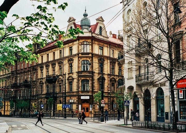 Кутовий будинок з вежею на вулиці європейського міста навесні