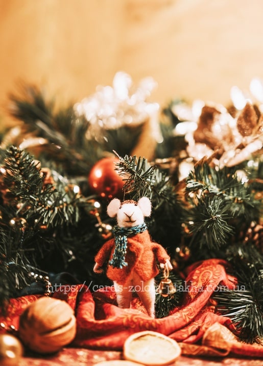 Filzmaus mit Schal zwischen Tannenzweigen und Christbaumkugeln