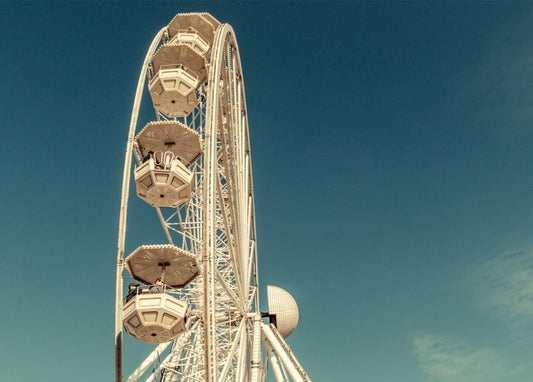 Retro getöntes Foto eines Riesenrads mit Gondeln vor tiefblauem Himmel