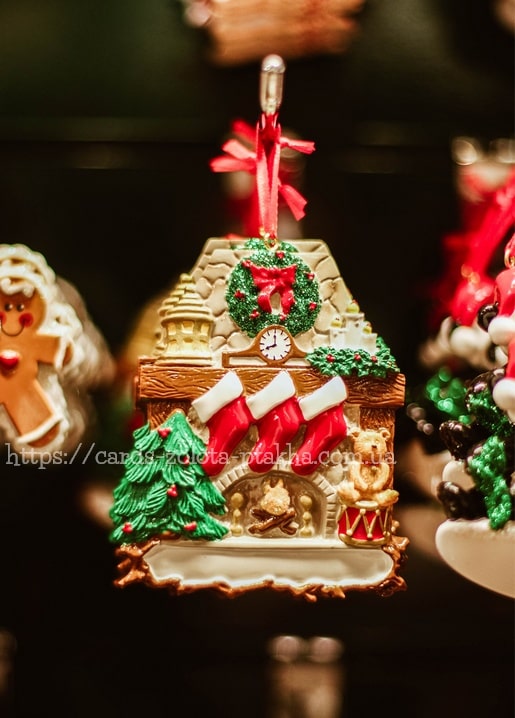 Miniatur-Kaminornament mit Kranz, Uhr und Strümpfen an einem roten Band