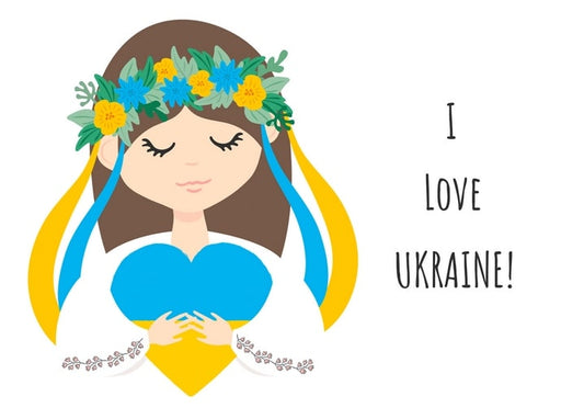 Mädchen mit Kornblumen-Blumenkranz hält blaues Herz neben dem Schriftzug „Ich liebe die Ukraine!“