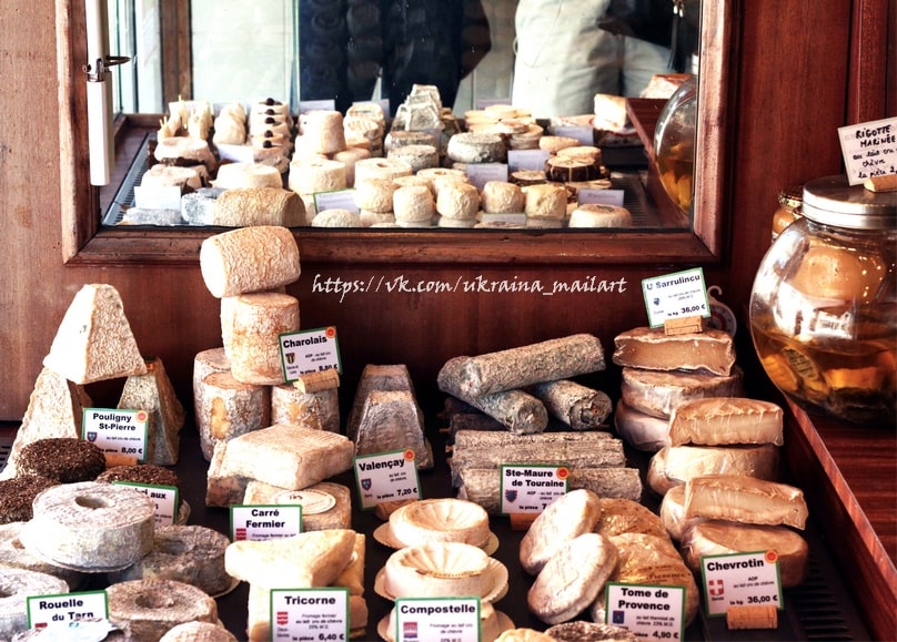 French fromagerie window display with named goat cheeses and price tags