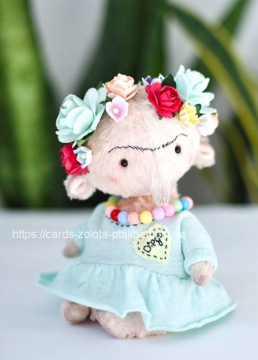 Postkarte mit Foto des ‚Frida‘-Teddybären mit Blumenkranz und Perlenkette