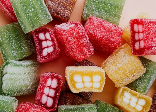Nahaufnahme gezuckerter roter, grüner und goldener Fruchtgelee-Bonbons im Anschnitt
