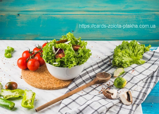 Bowl of lettuce salad with cherry tomatoes, green peppers and mushrooms on marble