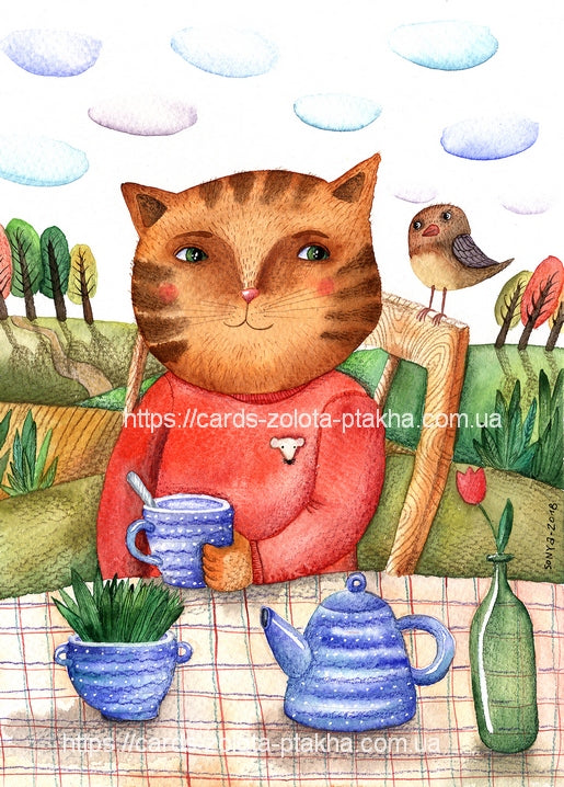 Рудий смугастий кіт у червоному светрі сидить за столом із чайником, горнятком і тюльпаном