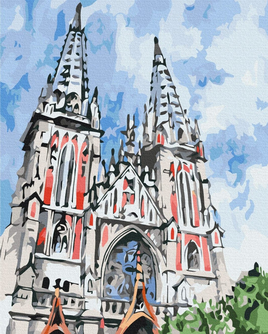 Gothic twin-spired church with rose-red stained glass windows against a blue sky