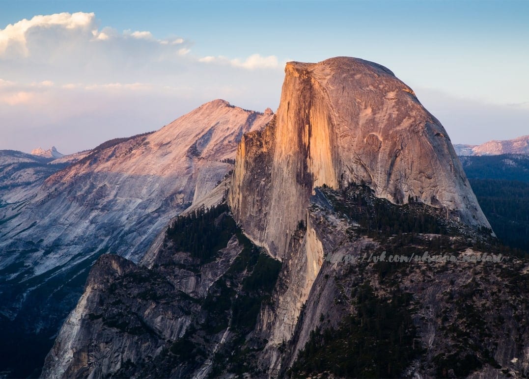 Massive granite dome mountain glowing gold in evening sunset light
