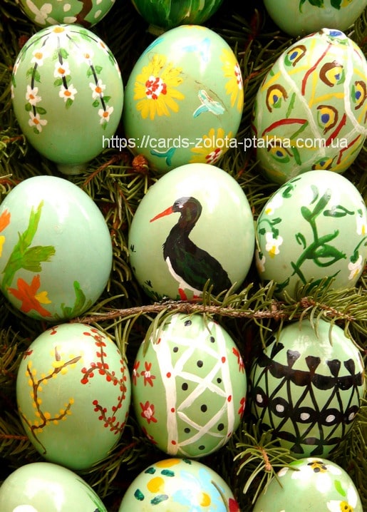 Hand-painted green Easter eggs with floral, geometric, and stork patterns