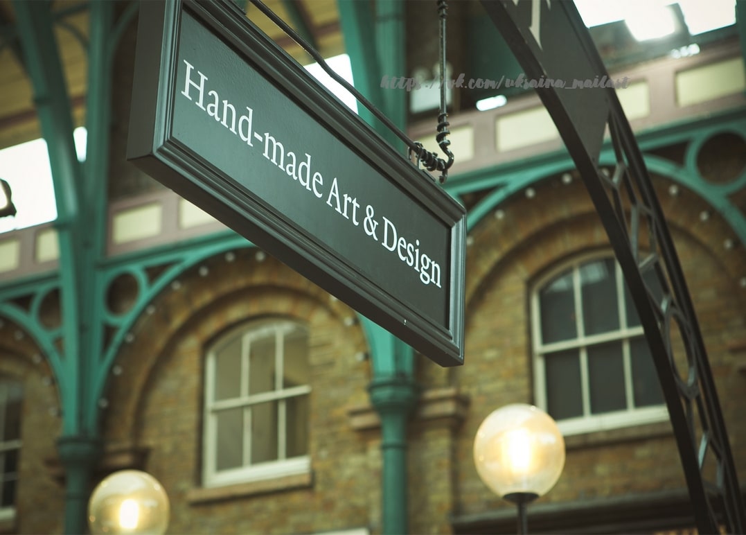 Handgemaltes Schild unter türkisfarbenem Schmiedeeisen-Dach einer Londoner Markthalle