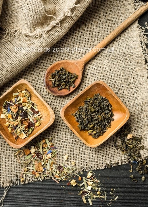 Wooden bowls of herbal and green tea with a spoon on burlap