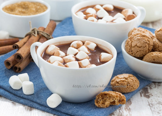 Три чашки какао з зефіром, паличками кориці й мигдальним печивом