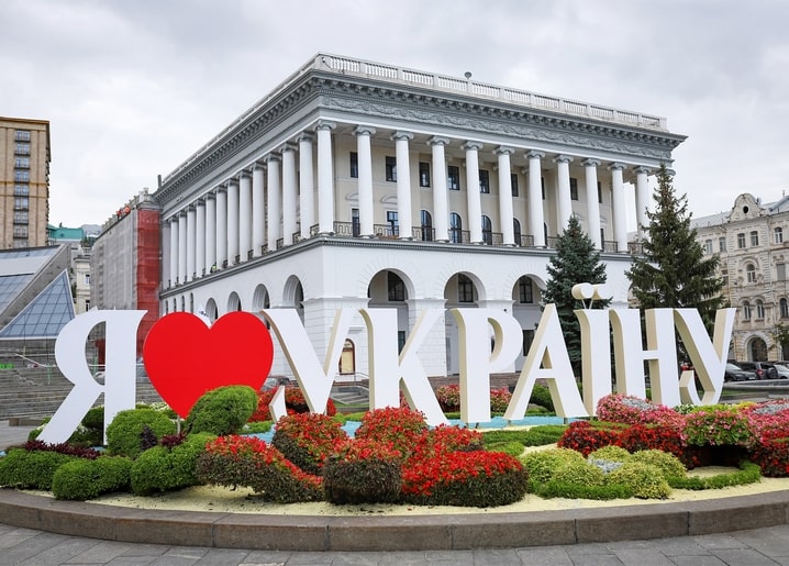 ‘I Love Ukraine’ sign with red heart and flower beds before a colonnaded building in Kyiv