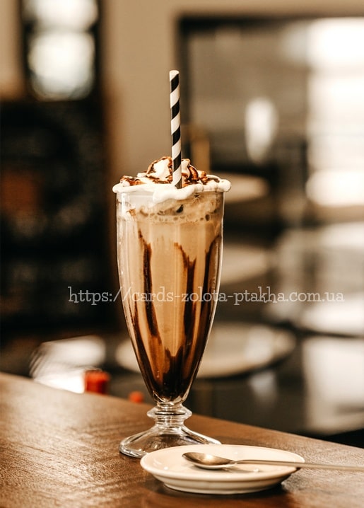 Hohes Eis-Mocha-Milchshake mit Sahne und Schokoladensauce auf einer Cafétheke