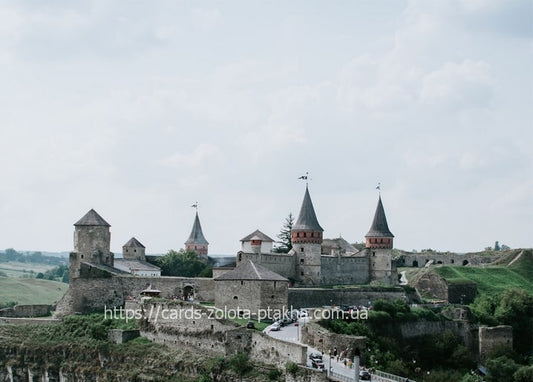Aerial view of Kamianets-Podilskyi Castle towers above a river canyon in Ukraine