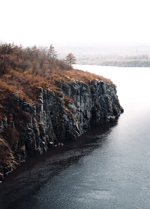 Felsige Klippen der Insel Chortyzja über dem nebligen Dnipro im Herbst