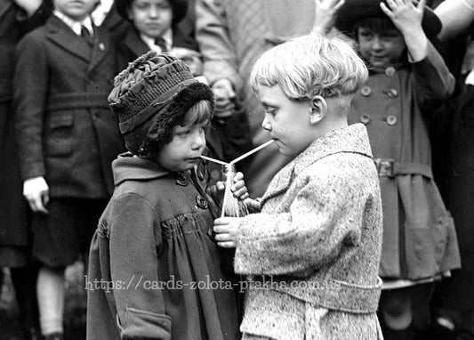 Vintage-Foto: Ein Mädchen und ein Junge trinken durch zwei Strohhalme, umringt von Kindern