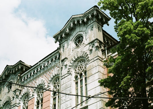 Upward view of an ornate Art Nouveau building facade in Kyiv with rosette windows