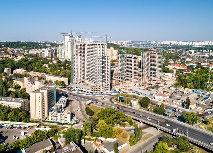Aerial view of Kyiv with new residential towers, construction cranes, and the city skyline