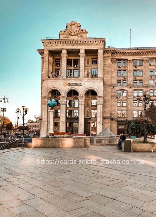 Kyiv's Ukrposhta post office building with globe monument at golden hour