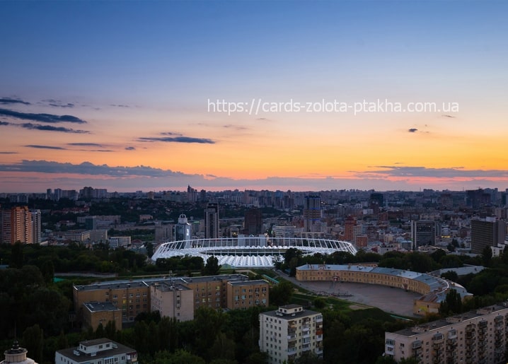 Kyiv skyline at sunset with the Olympic Stadium and city rooftops