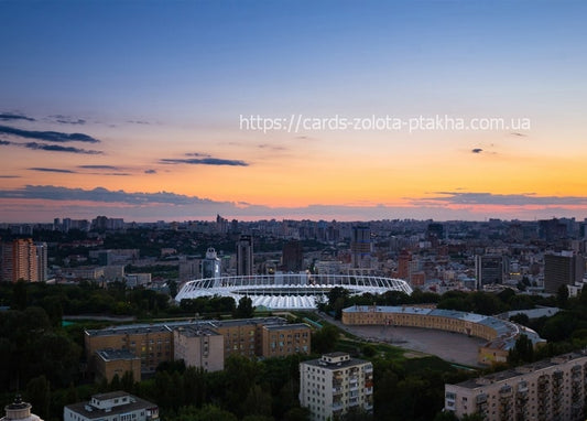 Kyiv skyline at sunset with the Olympic Stadium and city rooftops