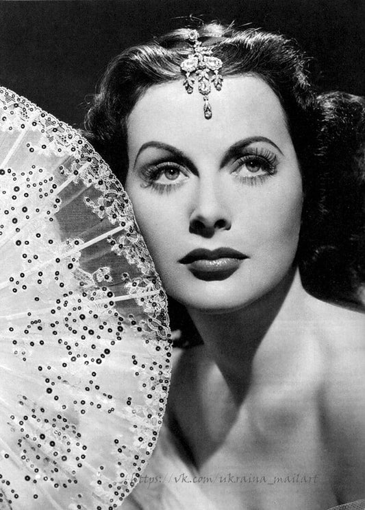 Vintage-Glamourporträt einer Frau mit Diadem, die einen Spitzenfächer mit Pailletten hält