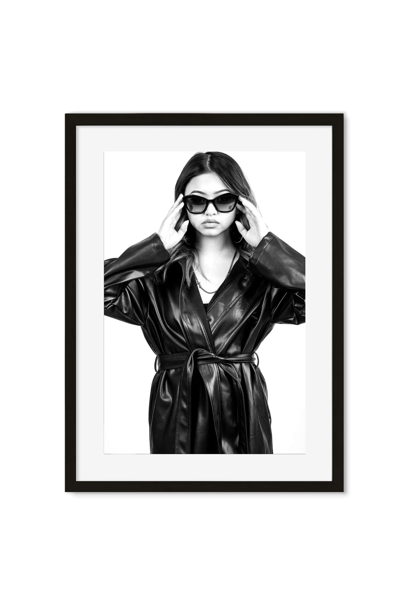 Black-and-white portrait poster of a woman in a leather coat adjusting sunglasses