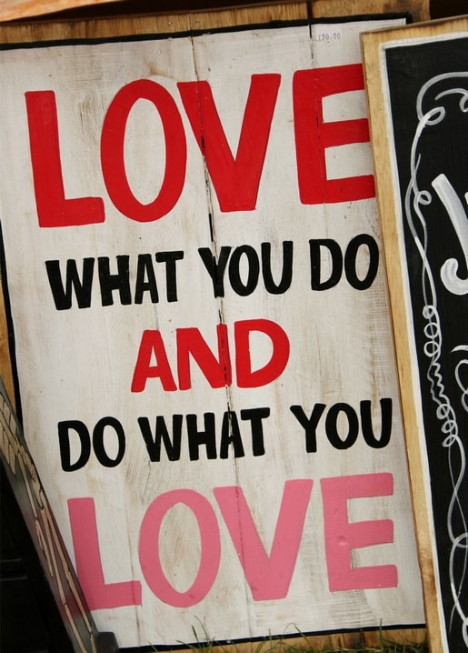 Дерев'яна табличка з написом “Love what you do and do what you love” біля чорної дошки