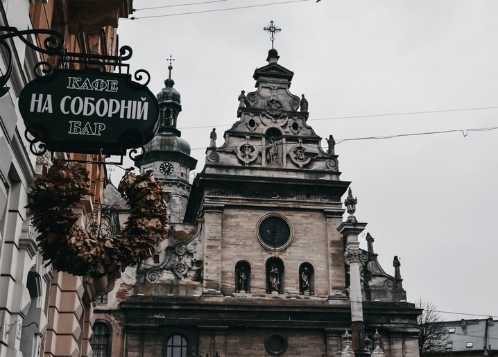 Vintage “Kafe na Sobornij” cafe sign beneath a Gothic cathedral facade in Lviv