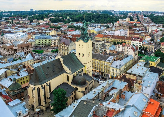 Панорама даху старого Львова з жовтою вежею костелу серед історичного центру міста.