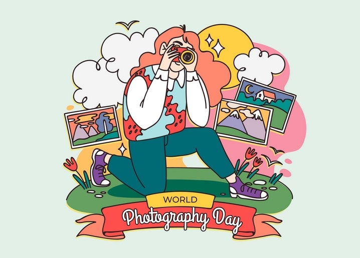 Man kneeling with a camera surrounded by colorful landscape photos for World Photography Day