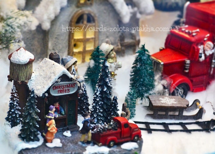 Verschneites Miniaturdorf mit Laden „Weihnachtsbäume“ und rotem Lieferwagen