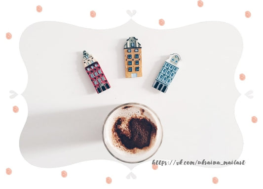 Drei winzige Giebelhäuser neben einem mit Kakao bestäubten Cappuccino