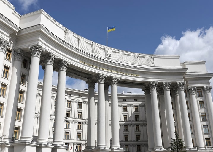 Вигнута коринфська колонада будівлі МЗС України в Києві на тлі синього неба