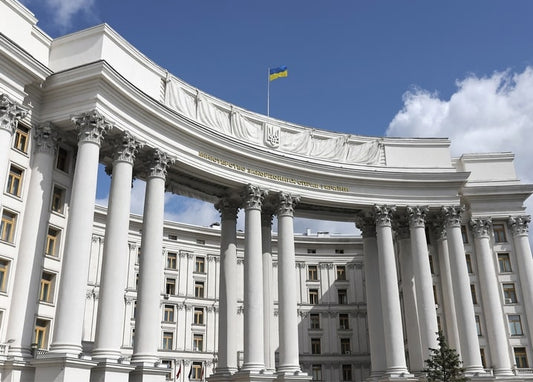 Вигнута коринфська колонада будівлі МЗС України в Києві на тлі синього неба