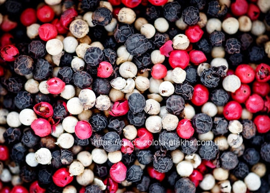 Macro close-up of black, white, and pink peppercorns densely packed together