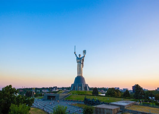 Монумент «Батьківщина-мати» в Києві на тлі вечірнього неба з молодим місяцем