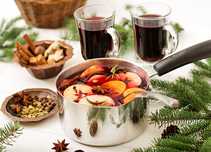 Pot of mulled wine with orange slices, cinnamon and star anise on a winter table