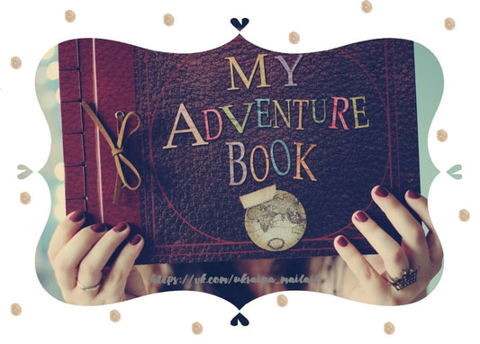 Руки тримають шкіряний щоденник «My Adventure Book» з мапою світу