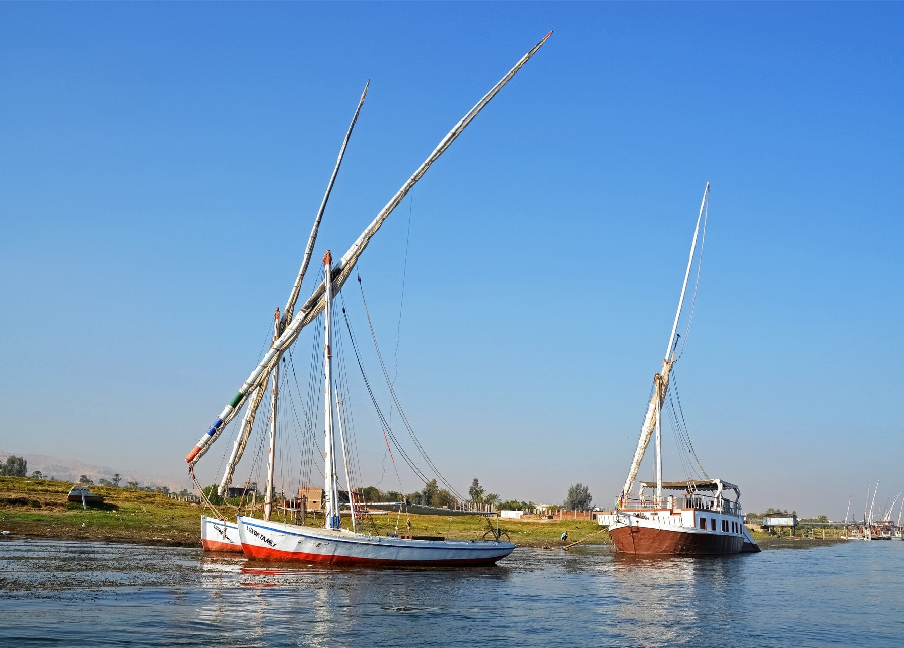 Zwei traditionelle Segelboote auf dem Nil unter klarem blauem Himmel