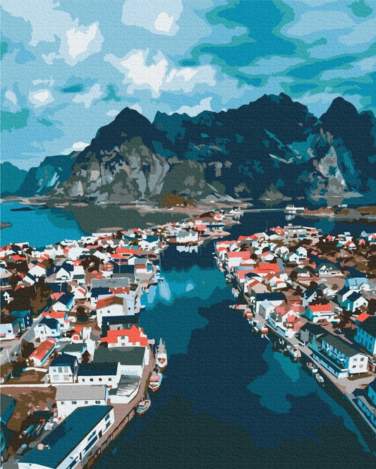 Aerial view of a red and white fishing village on a Norwegian fjord strait
